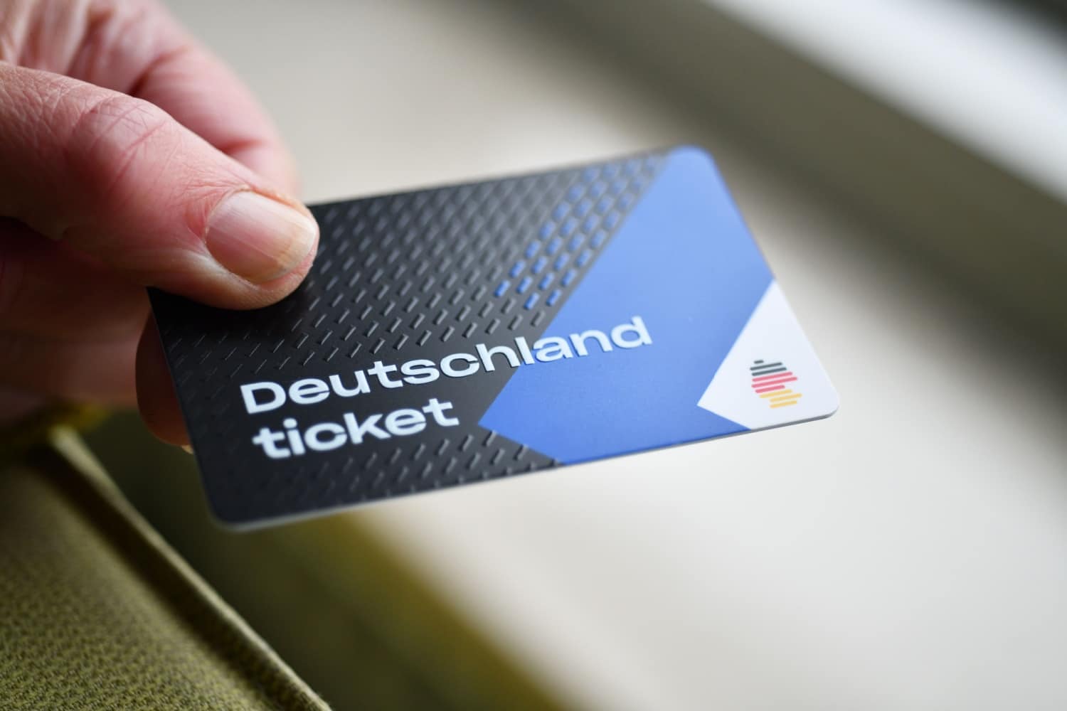 Hand hält Deutschlandticket