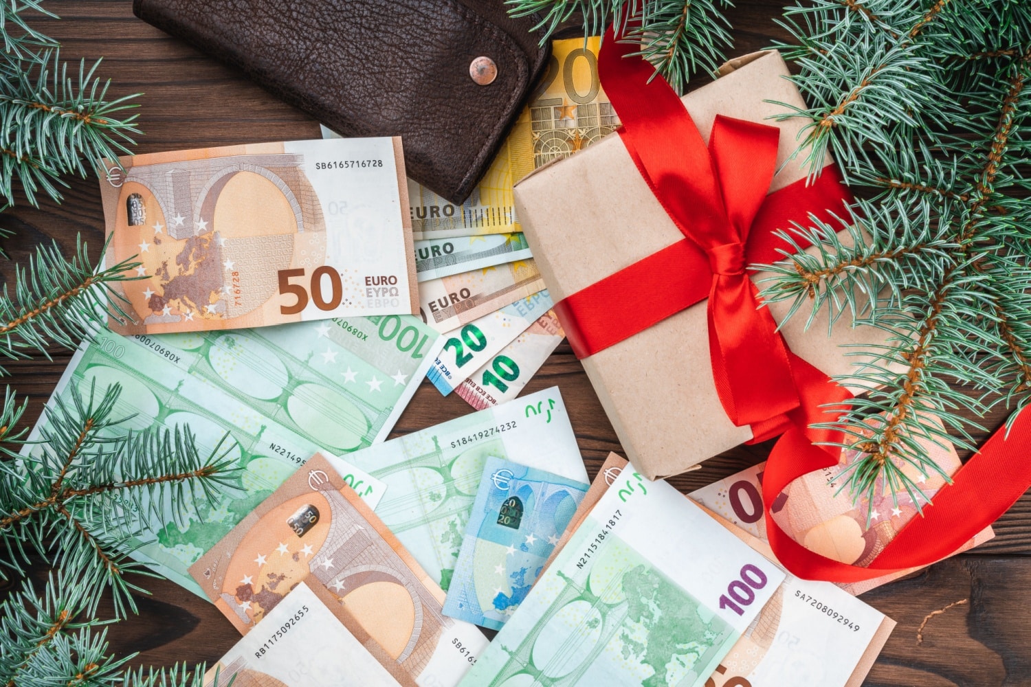 Euro Geldscheine mit Weihnachtsgeschenk und Tannengrün im Dezember