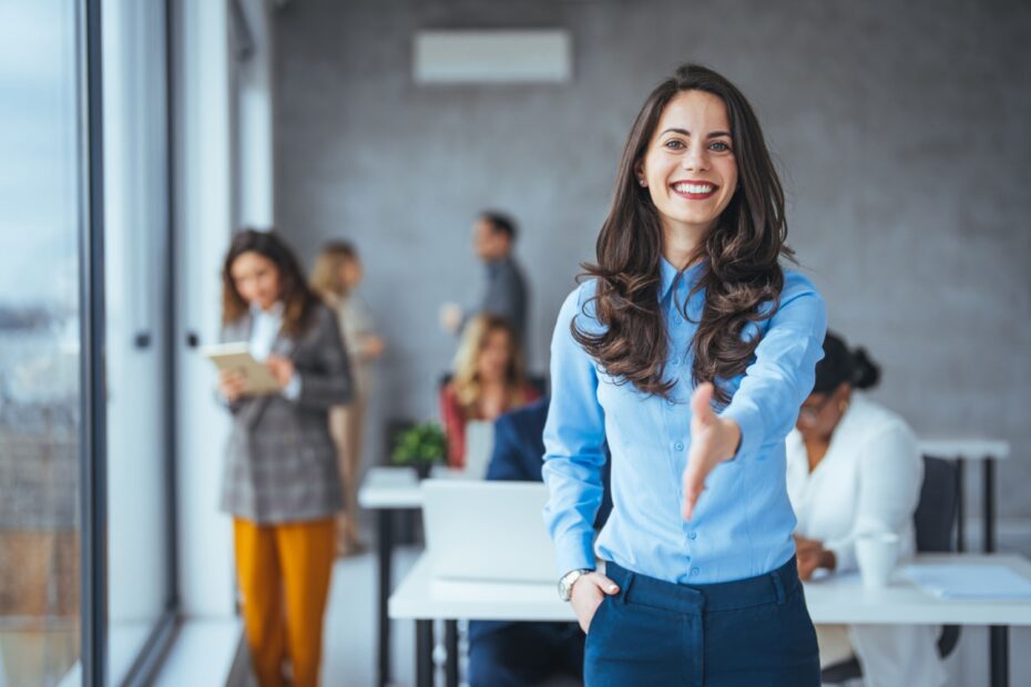 Frau begrüßt freundlich im neuen Job