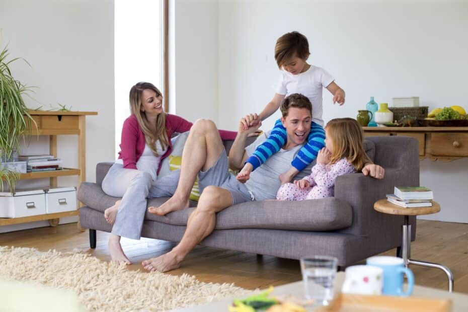 Eltern mit Kindern auf dem Sofa im Wohnzimmer.