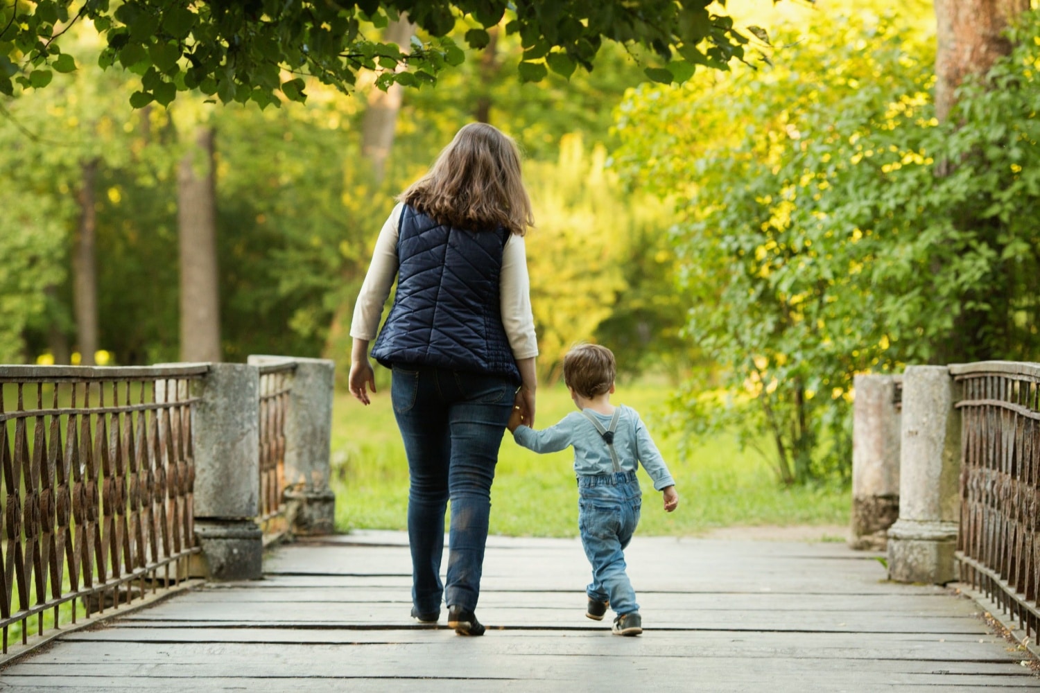 Mutter mit Kind auf Brücke im Park