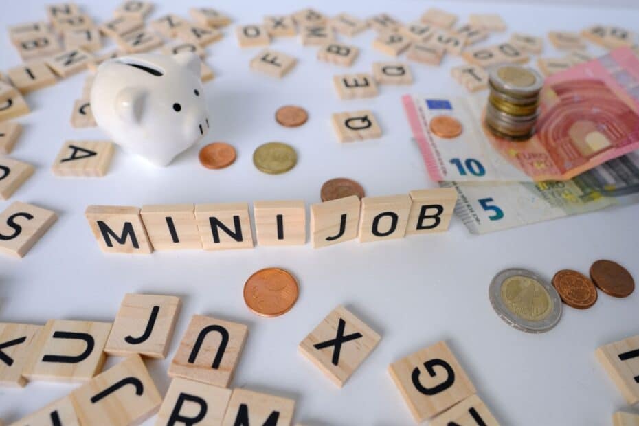 "Minijob" in Holzbuchstaben neben Sparschwein