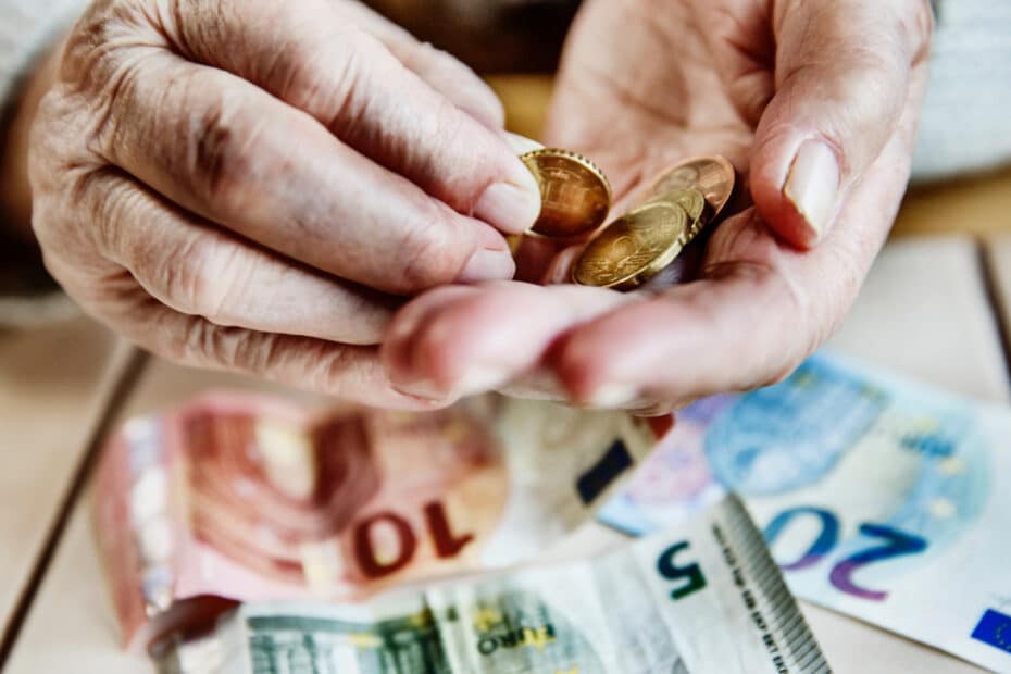 Hände eines Rentners beim Geld zählen